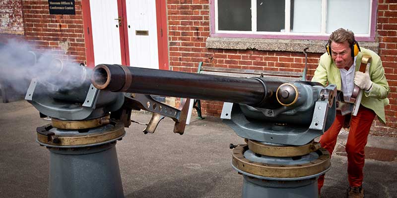 Michael Portillo firing a 3-pound Hotchkiss gun at Explosion Museum of Naval Firepower