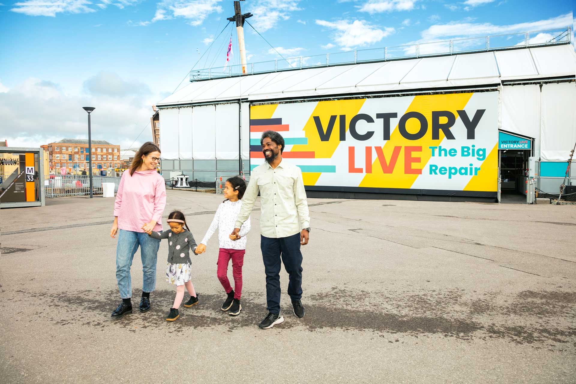 Family leaving Victory Live exhibition at Portsmouth Historic Dockyard in the sunshine