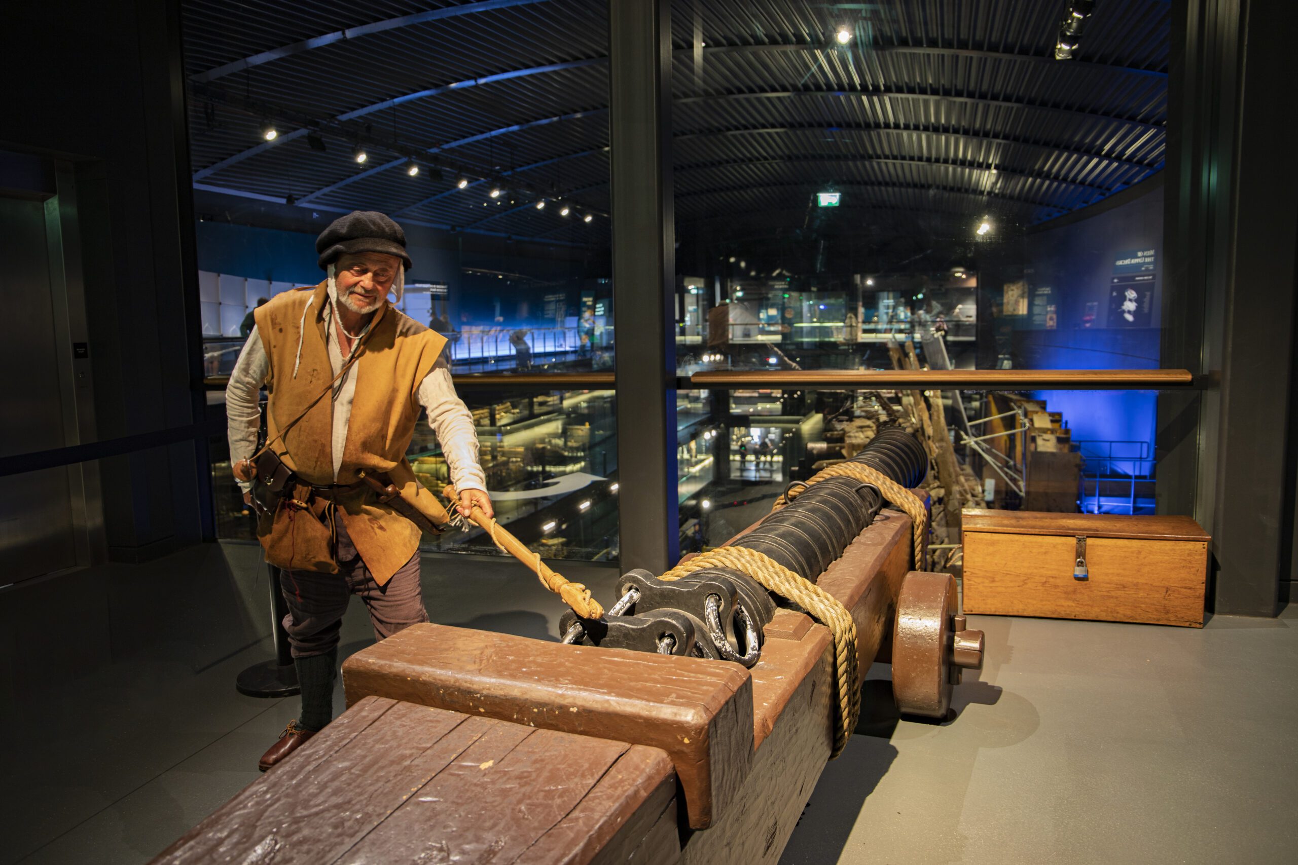 Man dressed as a Tudor pretends to fire a cannon inside the Mary Rose Museum