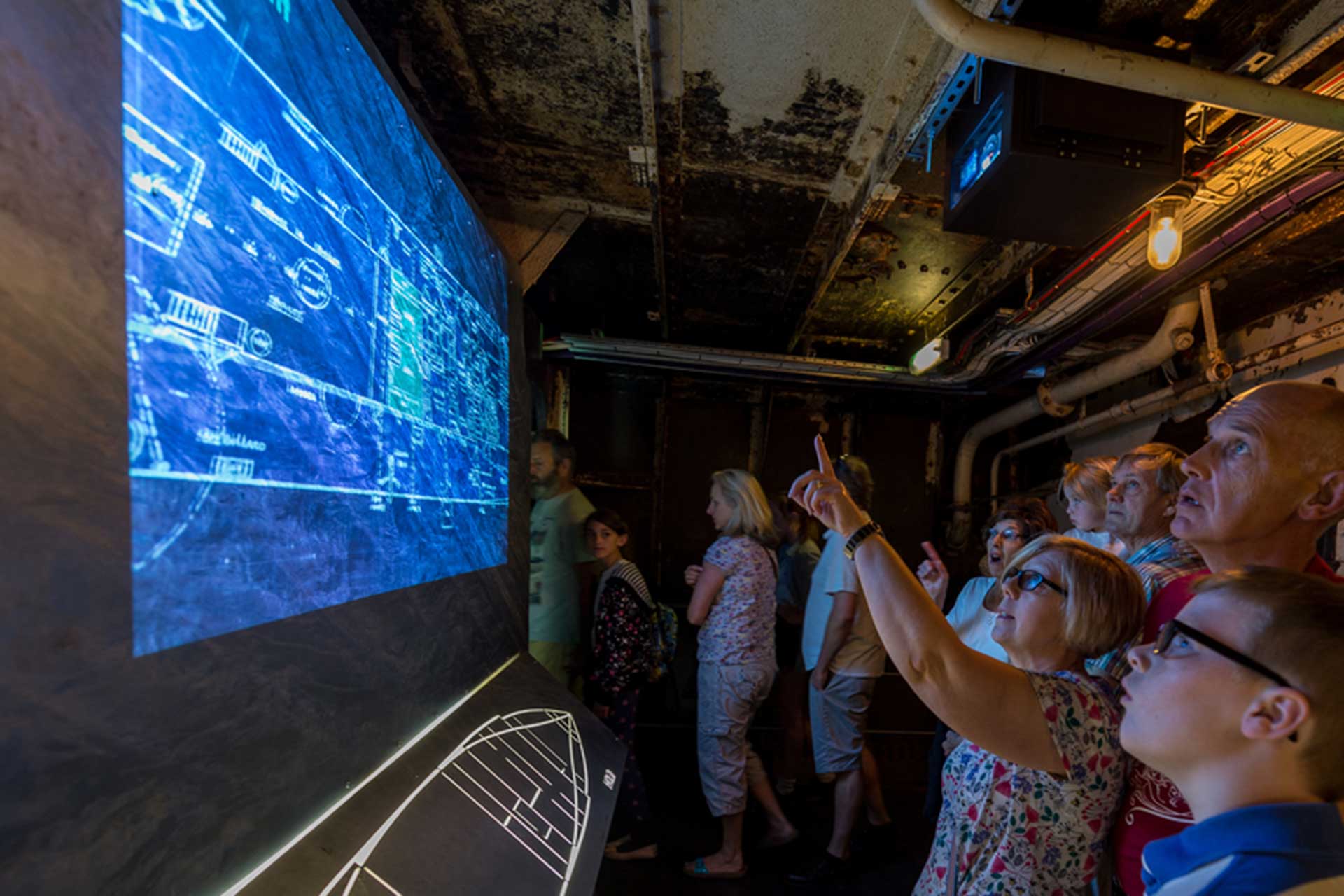 Family watching immersive display from inside M.33 at Portsmouth Historic Dockyard