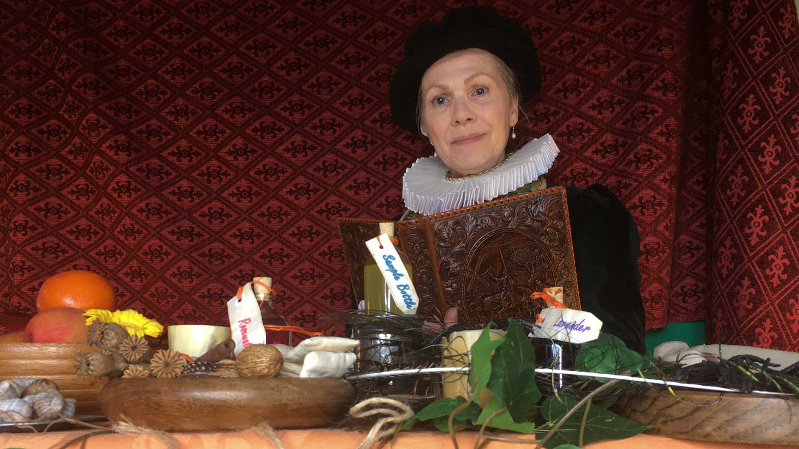 Woman in a Tudor outfit teaching 16th century medicine
