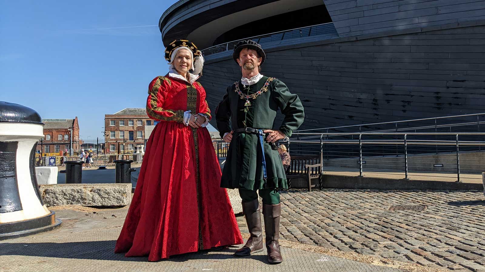 Two costume interpreters stand outside the Mary Rose Museum at Portsmouth Historic Dockyard